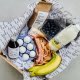 box containing pancake flour mix, maple syrup, buttermilk, eggs, butter, bacon, blueberries, bananas, recipe and tips